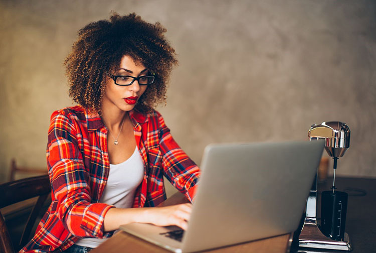  A woman sitting at a desk working on her laptop.