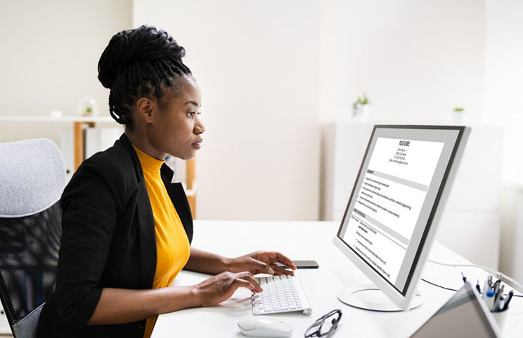  An employer reviews a resume displayed on a computer monitor.